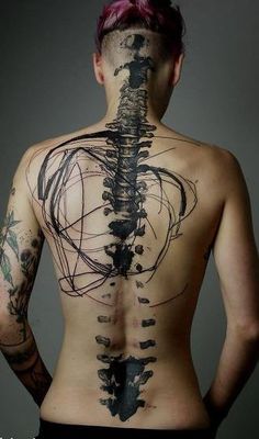 a man with his back turned to the camera and tattoos on his body is shown