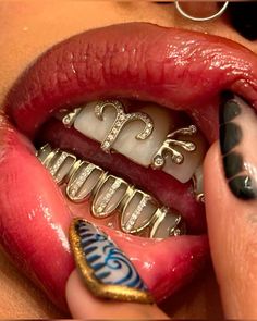 a close up of a person's mouth with some jewelry on it and her tongue