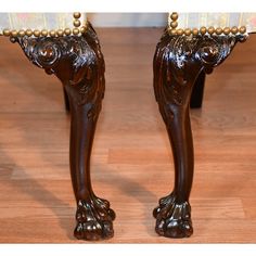 an ornately carved wooden foot stool with gold accents