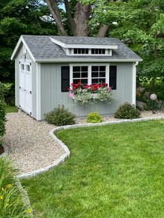 a garden shed with flowers in the window