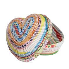 a heart shaped bowl filled with lots of different colored paper strips on top of each other