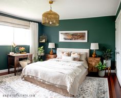 a bedroom with dark green walls and white bedding, two nightstands on either side of the bed