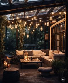 an outdoor living area with lights strung from the ceiling and couches on the deck