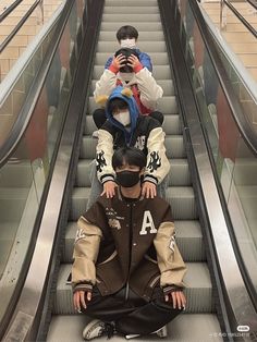 two people sitting on an escalator with their faces covered by masks