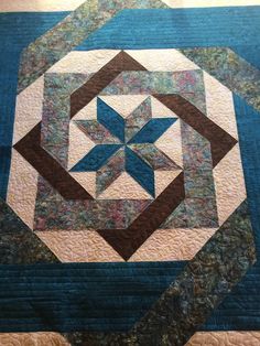 a blue and brown quilt with a star on it