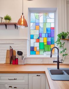 a kitchen with a sink, window and potted plant