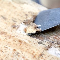 a knife that is on top of a wooden table with dirt all over the surface