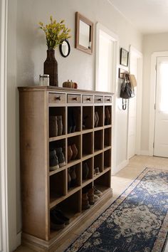 there is a shoe rack with many pairs of shoes on it in the entryway