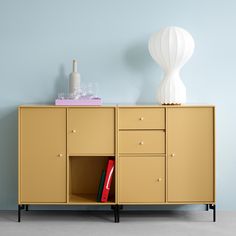 a sideboard with drawers and a lamp on top