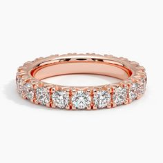 a rose gold wedding band with five round diamonds on the side and an oval diamond in the middle