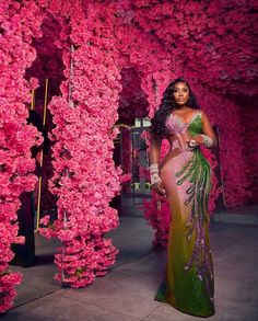 a woman standing in front of pink flowers