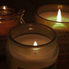 three lit candles sitting next to each other