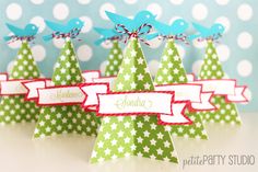 small christmas trees with ribbons and bows on them are sitting in front of polka dot wallpaper