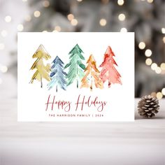 a holiday card with watercolor trees on it