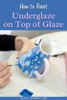 someone is using a blue and white vase to paint the top of a glaze