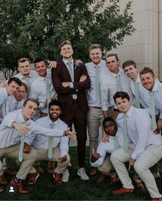 a group of men in suits and ties posing for a photo with their arms around each other