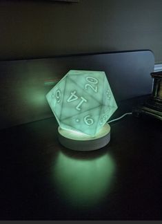 a glowing light that is on top of a table next to a clock and lamp