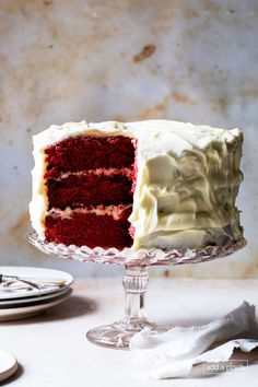 a red velvet layer cake with white frosting