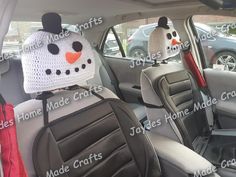 the interior of a car with two snowman hats on