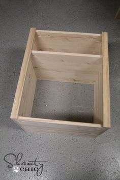 a wooden box sitting on top of a cement floor