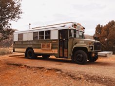 an old school bus is parked in the dirt