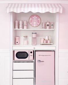 a pink stove top oven sitting inside of a white kitchen next to a shelf filled with cups