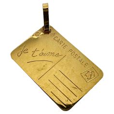 A French 18 karat (18K) yellow gold love letter charm pendant designed as a postcard with blank address field, stamp and the words 'Je t'aime' in cursive to one field. Stamped with the eagle's head for French manufacture and 18 karat gold and an unknown maker's mark. Dimensions: 1.7 x 1.2 x 0.05 cm (not including jump ring) Weight: 1.24 grams (Chain not included) Gold Heart Locket, In Cursive, Lucky Horseshoe, Letter Charm, Locket Charms, Love Charms, Letter Charms, Vintage Jewels, Heart Locket