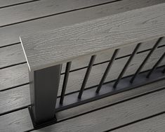 a close up of a metal railing on a wooden decking area with wood slats