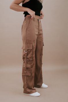 The Silk Cargo Pants in Coco are a luxurious and versatile addition to your wardrobe. These cargo pants offer a blend of comfort and style. The coco color exudes elegance, and the silk material adds a touch of refinement to your look. Silk cargo pants Two back pockets Two side hip pockets Three cargo pockets Button and zipper closure Belt loops Elastic waistband in the back for added comfort Fabric Contents: 100% POLYESTER Inseam: Small 30 in Medium 30.25 in Large 30.50 in Rise: Small 11.25 in M Luxury High-waisted Cargo Pants With Patch Pockets, Luxury Khaki Cargo Style Bottoms, Luxury Spring Cargo Pants With Hip Pockets, Luxury High-waisted Cargo Pants With Side Pockets, Luxury Cargo Pants With Hip Pockets For Spring, Luxury High Waist Cargo Pants With Belt Loops, Luxury Fall Cargo Pants With Patch Pockets, Luxury Chic Relaxed Fit Cargo Pants, Luxury High Rise Cargo Pants With Pockets