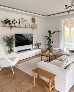 a living room filled with furniture and a flat screen tv mounted on a wall above a wooden coffee table