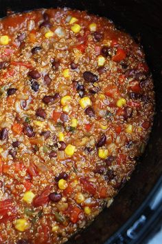 a crock pot filled with beans, corn and other things to eat in it