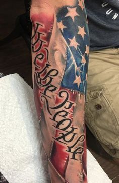 a man's arm with an american flag and words on it