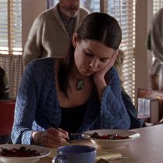 a woman sitting at a table with plates of food