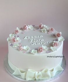 a white cake decorated with pink and white flowers