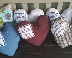 four heart shaped pillows sitting on top of a wooden bench