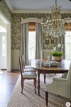 a dining room table with four chairs and a chandelier hanging from the ceiling