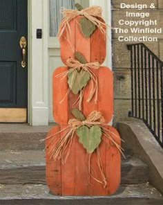 three pumpkins stacked on top of each other in front of a door with the words design & image copyright the whitfield collection