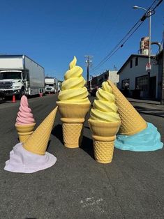 three ice cream cones sitting in the middle of a street