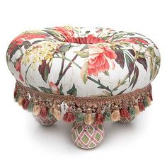 an ottoman with flowers and tassels on it