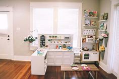 a living room filled with furniture and lots of shelves on the wall next to a window