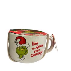 the grinly stole christmas coffee mug has a santa hat on it's head