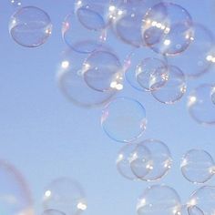 soap bubbles floating in the air against a blue sky