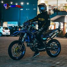 a person sitting on a dirt bike in the middle of a city street at night