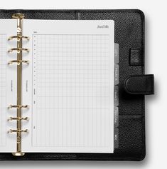 a black and white planner book with gold ring binders on it, open to the page