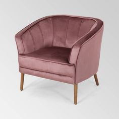 a pink velvet chair with wooden legs