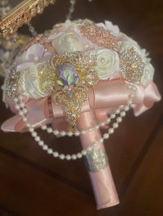 the bridal bouquet is adorned with pearls and roses, along with other accessories such as brooches