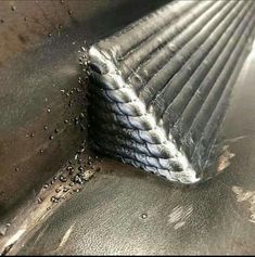 a piece of metal sitting on top of a table next to a pile of dirt