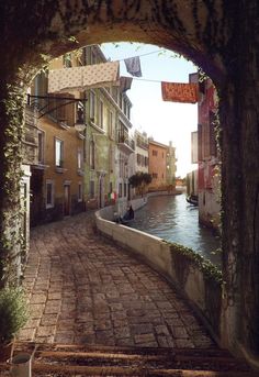 an archway leading to a canal with buildings on both sides