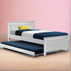 a white bed frame with blue sheets and yellow pillows on it in a pink room