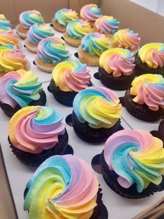 cupcakes with rainbow frosting in a box